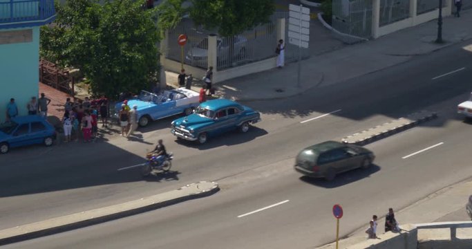 A high angle aerial view of classic cars traveling on the streets of Havana, Cuba.	