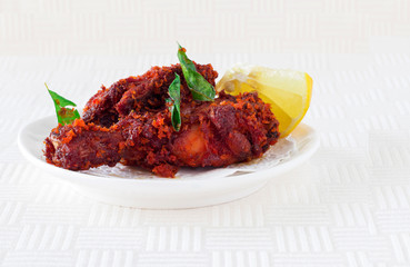 Authentic Indian Chicken fry with spices, curry leaf and coconut - payyoli chicken fry. Famous Kerala course. Copy space. White background