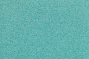 Texture of old turquoise paper closeup. Structure of a dense cardboard. The green background.