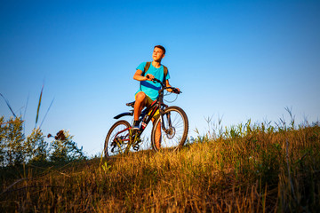 Fototapeta na wymiar The boy on bicycle and sunset.