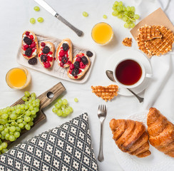 Breakfast in bed with croissants, raspberry and blackberry bruschetta.  Morning treat concept.