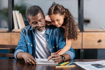 African american man drawing with daughter