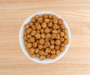 Serving of chickpeas with sea salt in a white bowl atop a wood table.