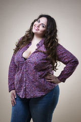 Plus size fashion model in casual clothes, fat woman on beige studio background, overweight female...