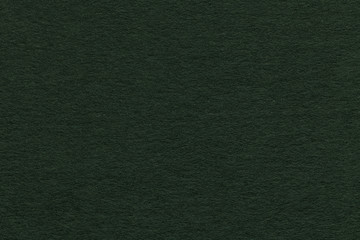 Texture of old green paper closeup. Structure of a dense cardboard. The black background.
