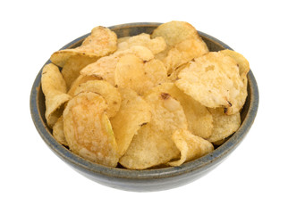 Stoneware bowl filled with salt and vinegar flavored potato chips isolated on a white background.