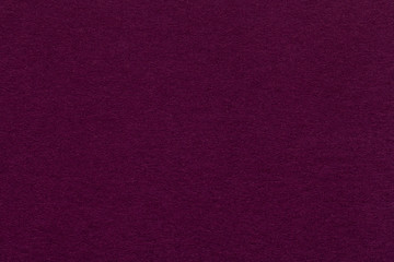 Texture of old dark purple paper closeup. Structure of a dense cardboard. The magenta background.