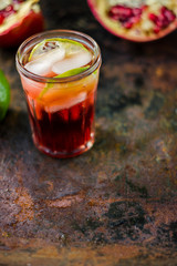 Fresh pomegranate drink - lemonade or cocktail with lime and ice