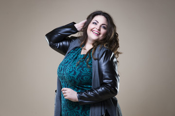 Plus size fashion model in casual clothes, fat woman on beige studio background, overweight female...