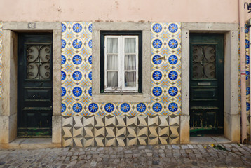 Facade of a Portuguese house decorated with vintage Portuguese tiles (azulejos)