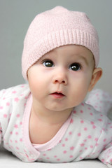 baby M&auml;dchen mit M&uuml;tze staunt mit gro&szlig;en Augen