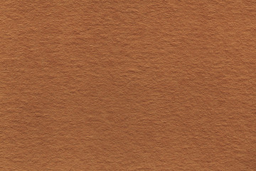 Texture of old light brown paper closeup. Structure of a dense cardboard. The bronze background.