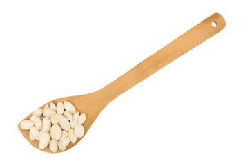 Top view of roasted and salted pumpkin seeds in a spoon isolated on a white background.