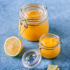 Lemon Curd in Jars over Blue Background