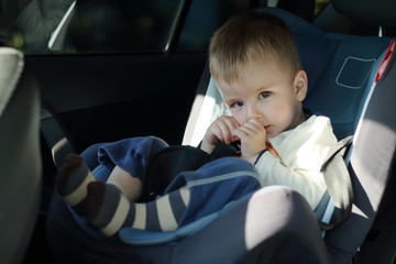 Little boy sitting on the car seat