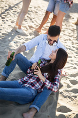 Happy couple having fun and drinking at beach