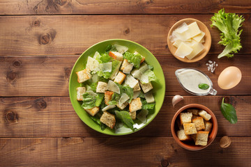 caesar salad and ingredients at wood