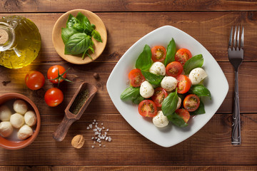 caprese salad and ingredients at wood