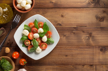 caprese salad in plate at wood