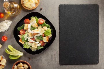 caesar salad and ingredients at table