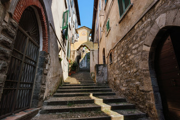 Fototapeta na wymiar Narrow streets of authentic Bellano fishing village, situated on Como Lake shore. Traditional italian houses, stone steps and arcway in small town Bellano, Lombardy, Italy.