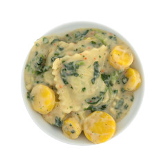 Top view of a ravioli with spinach meal in a bowl isolated on a white background.