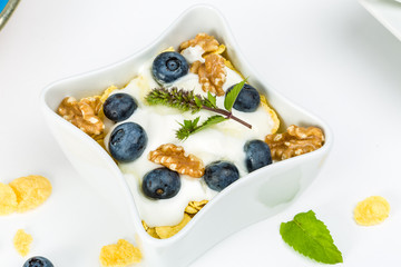 Corn flakes with yoghurt, honey, walnuts and blueberries