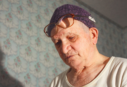 sad senior man in Knitted hat and glasses