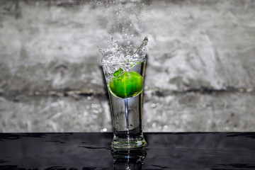 Throw lime into a glass of water, splashing water over glass.