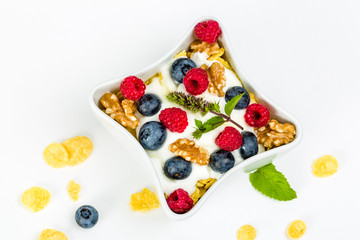 Corn flakes with yoghurt, honey, walnuts raspberries and blueberries