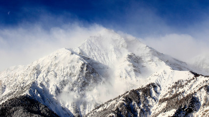Fototapeta na wymiar Blowing snow of mountain with a blow sky 