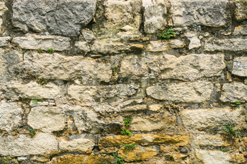 Background texture of old antique wall made of cracked bricks and stones
