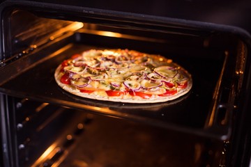 Pizza baking in the oven (close)