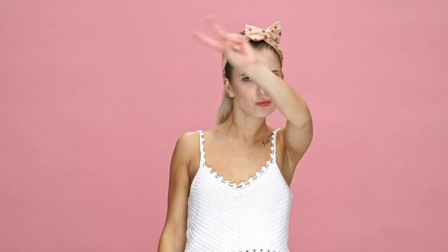 Young amazing caucasian woman dancing over pink background