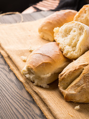 Freshly baked bread loaves on burlap dark wooden background. Texture closeup italian bakery products