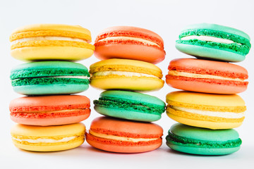 Multicolored macaroons (orange, yellow and green) close.