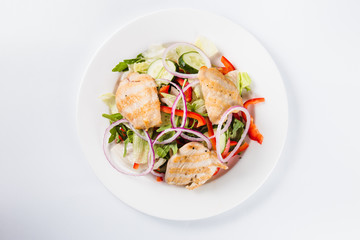 salad with chicken on a white plate on a light background (top view close)