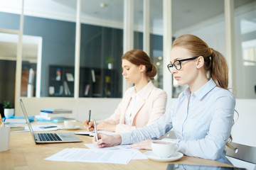 Obraz na płótnie Canvas Businesswomen concentrating on paperwork or financial analysis