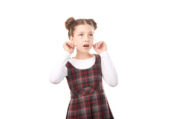 Portrait of cute girl in school uniform feeling fear against white background