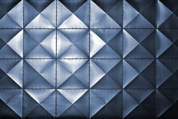 Embossed square metal tiles on a wall