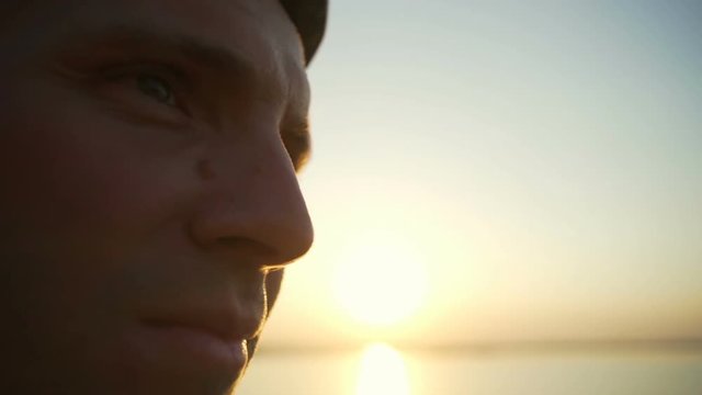 Close up man in helmet with mole on nose seaview sunset rapid slow motion 