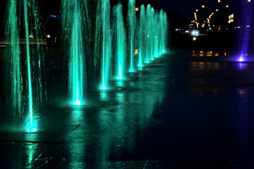 City fountain warm summer night and colorful illuminations