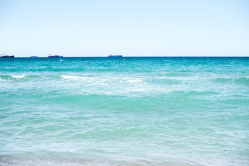 Fototapeta na wymiar Sand and sea waves on beach at resort, sand texture