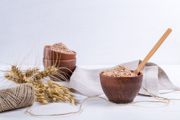 Wheat, Oat bran in clay  bowl and ears of wheat and oat.  Dietary supplement to improve digestion....