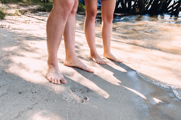 Feet in love bet on a sandy beach by the sea