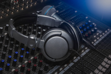 Obraz na płótnie Canvas Headphones and Microphone on sound music mixer control panel.