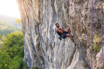 Rock climber bouldering outdoors on mountain in nature