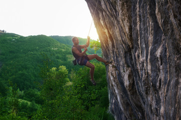 Rock climber bouldering outdoors on mountain in nature