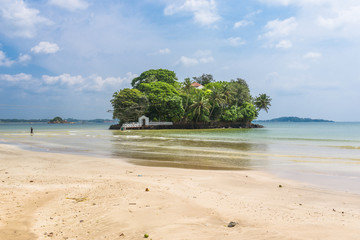 The white sandy beach and bay of Weligama with Taprobane Island in the foreground. Originally called Galduwa in Sinhalese, it means rock island. The beach in the south is very popular with surfers.	