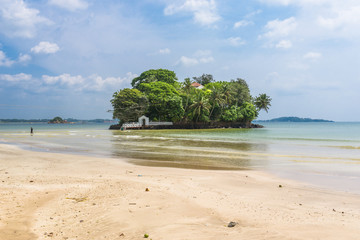 The white sandy beach and bay of Weligama with the island Taprobane in the foreground. Originally in Sinhalese called Galduwa, means Rock Island. The beach in the south  is very popular among surfer